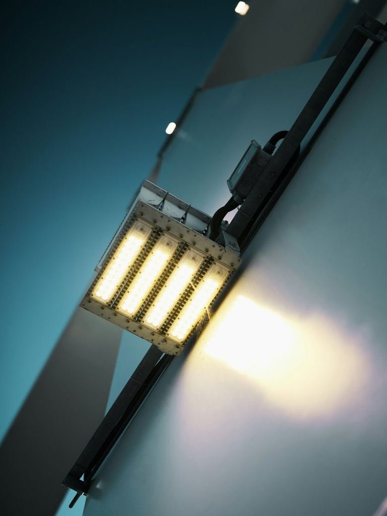 LED floodlight module switched on, mounted on its bracket