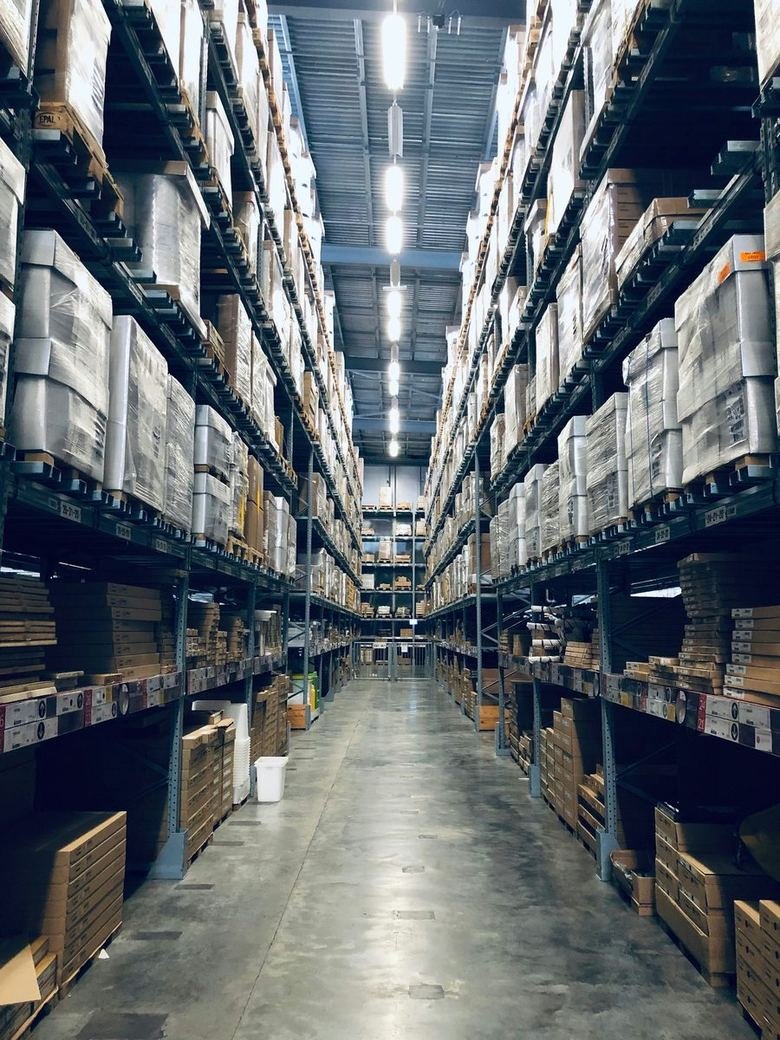Warehouse aisle with linear luminaires switched on overhead